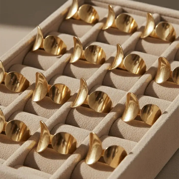 Set of gold rings in a display box on a neutral background