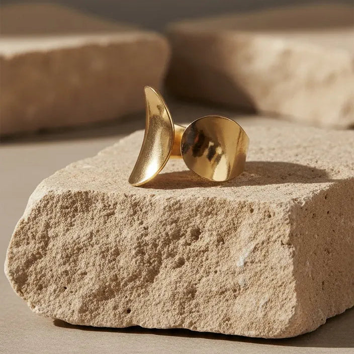 Gold ring on a stone surface with a neutral background